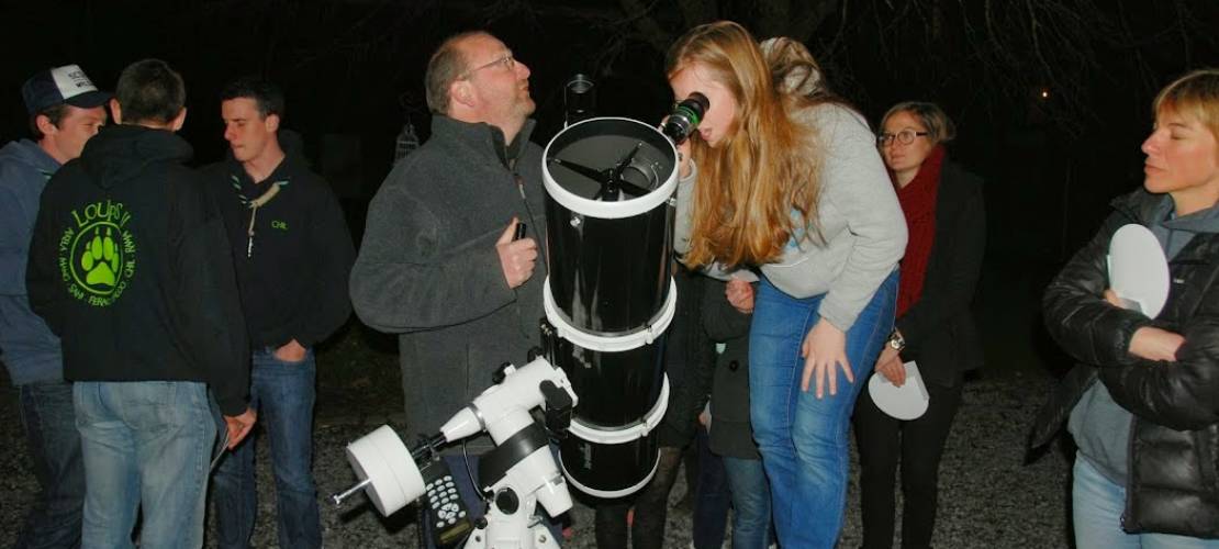 Des personnes observant le ciel avec un telescope 