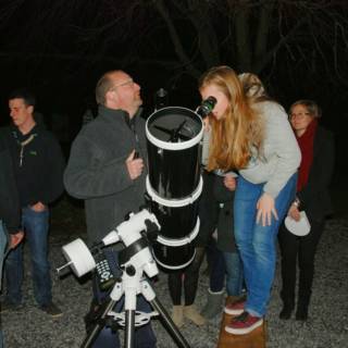Des personnes observant le ciel avec un telescope 