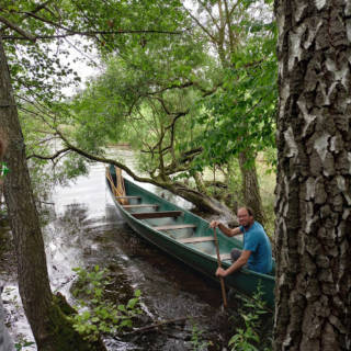 Un monsieur se tenant dans un canoë prêt à partir
