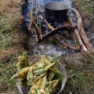 Une casserole chauffe sur un feu avec de la nourriture sur le côté