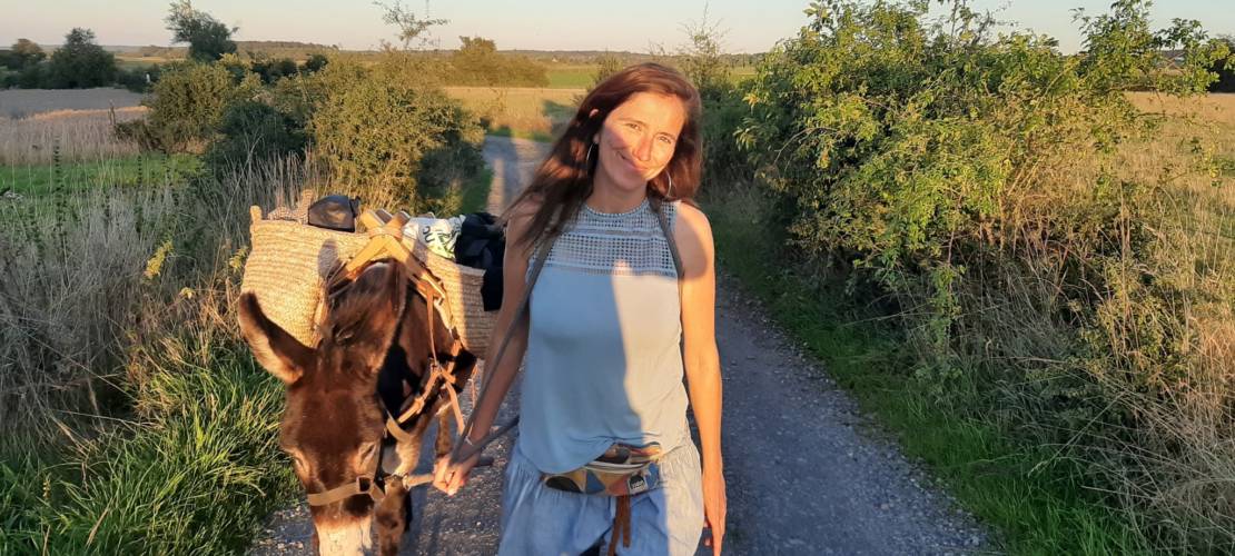 Une dame tenant l'âne durant une balade
