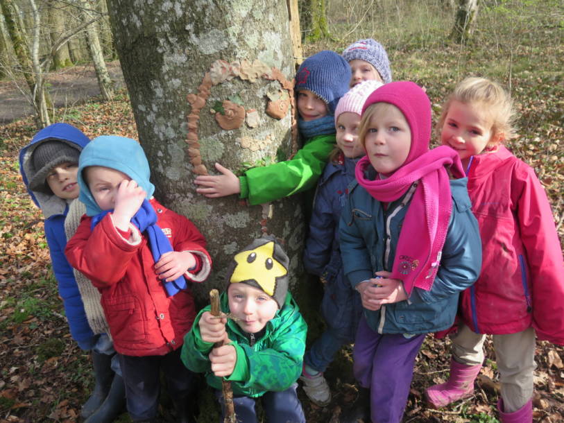 Un groupe d'enfant avec une oeuvre d'art réaliser avec de l'argile sur un arbre